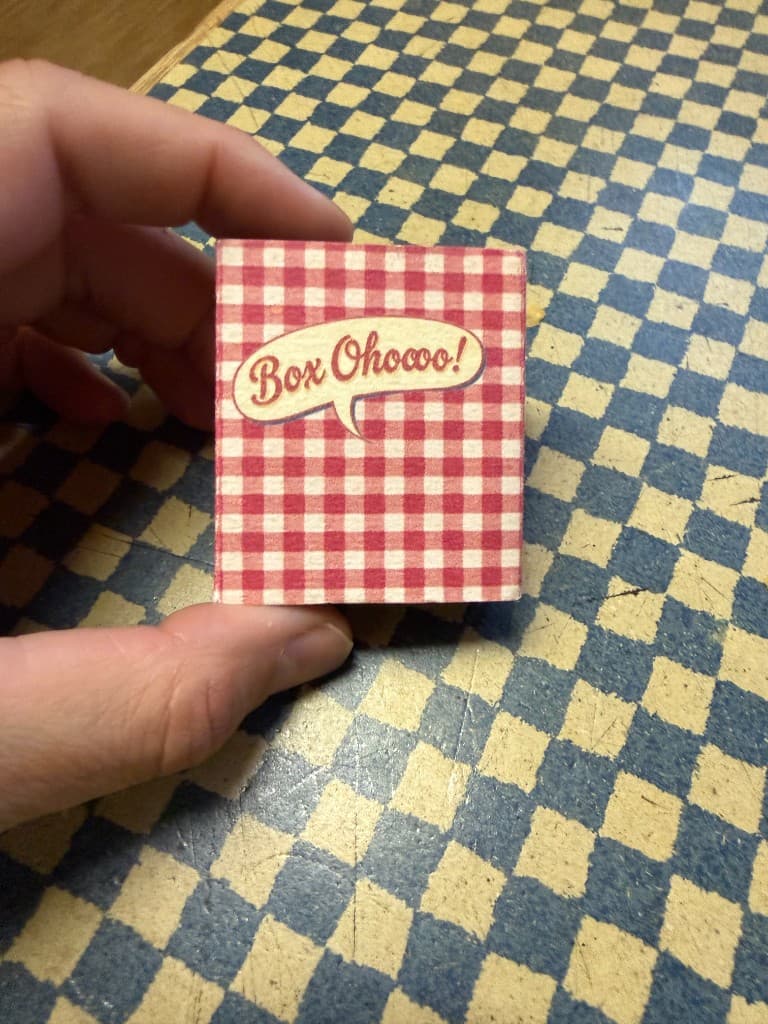 Geschlossenes Boxoho-Böxchen, zwischen zwei Fingern gehalten
